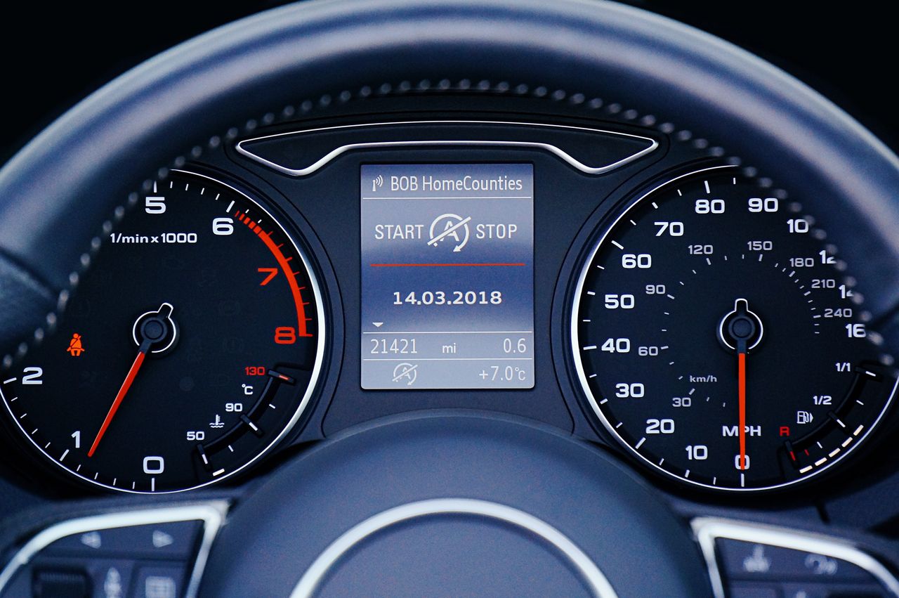 Close-up of a car dashboard displaying speedometer, tachometer, and digital display with mileage.